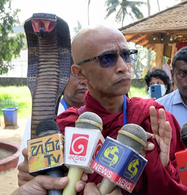 former-pohottuwa-mp-gratian-wears-a-robe-and-carries-a-naga-bag-on-a-new-march