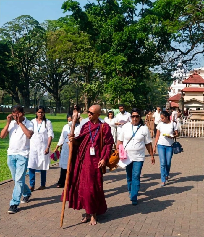 former-pohottuwa-mp-gratian-wears-a-robe-and-carries-a-naga-bag-on-a-new-march